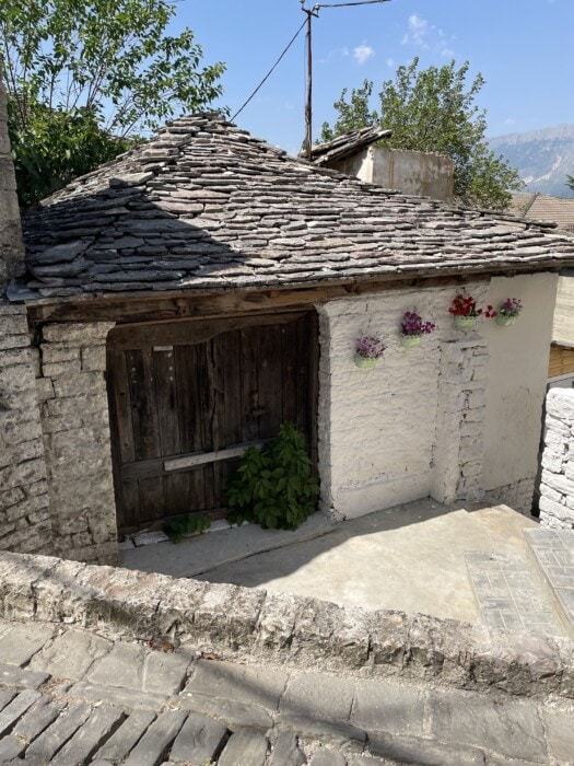 old home with purple flowers Gjirokaster Albania Travel itinerary